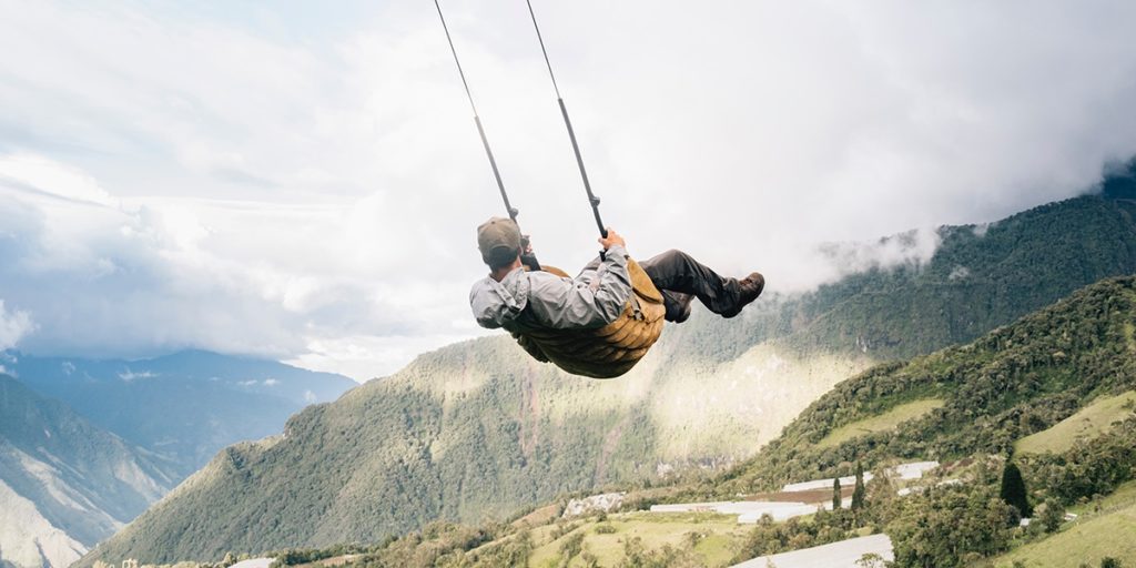 man swinging over a cliff at the  swing at the end  of the world in baños ecuador