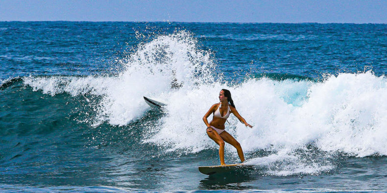 mulher surfando na praia - o que fazer em montañita equador